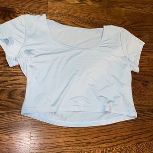 Very cropped light blue t-shirt. NEVER WORN.